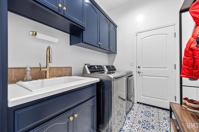 clothes washing area with light tile patterned floors, independent washer and dryer, a sink, and cabinet space