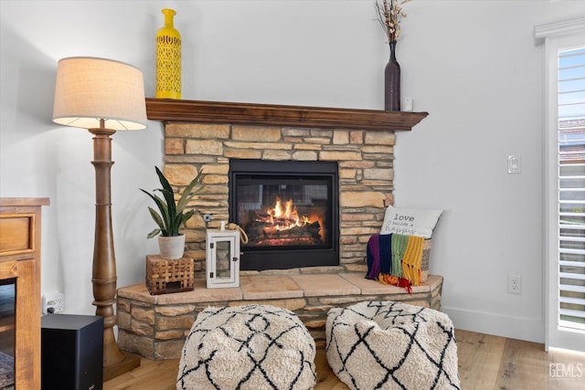 room details featuring a fireplace, wood finished floors, and baseboards