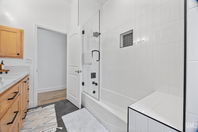 bathroom with tub / shower combination, vanity, and baseboards