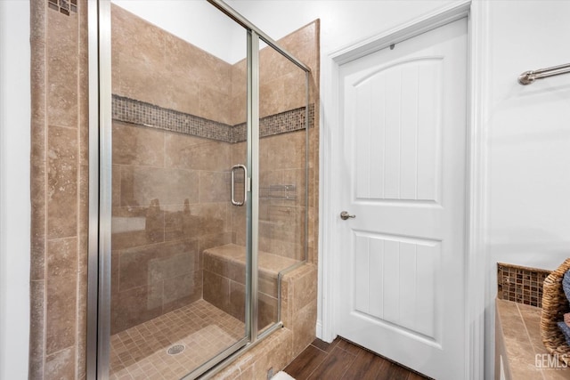 full bath featuring a shower stall and wood finished floors