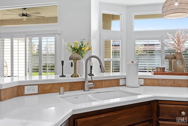 kitchen featuring a ceiling fan, light countertops, and a sink