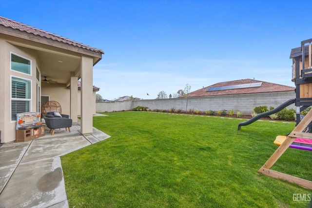 view of yard with a patio, a playground, and a fenced backyard