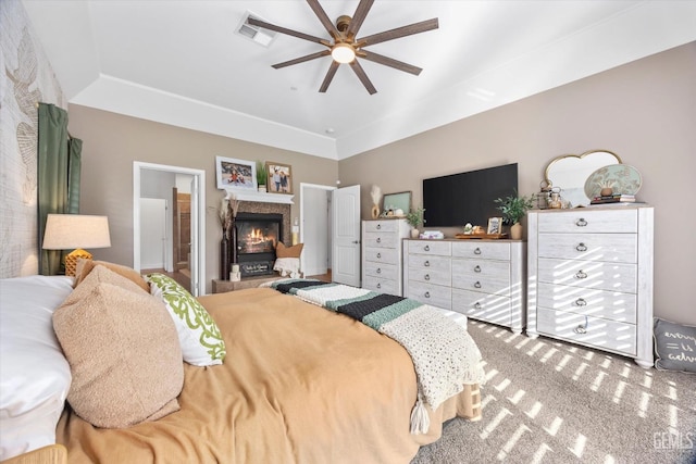 bedroom featuring ensuite bath, visible vents, ceiling fan, and a glass covered fireplace