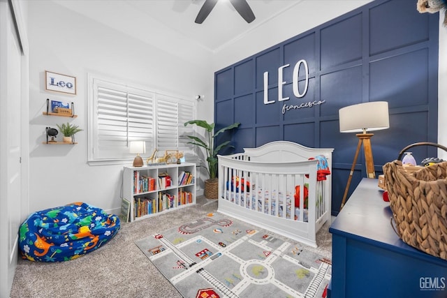 bedroom featuring carpet floors, ceiling fan, and a decorative wall