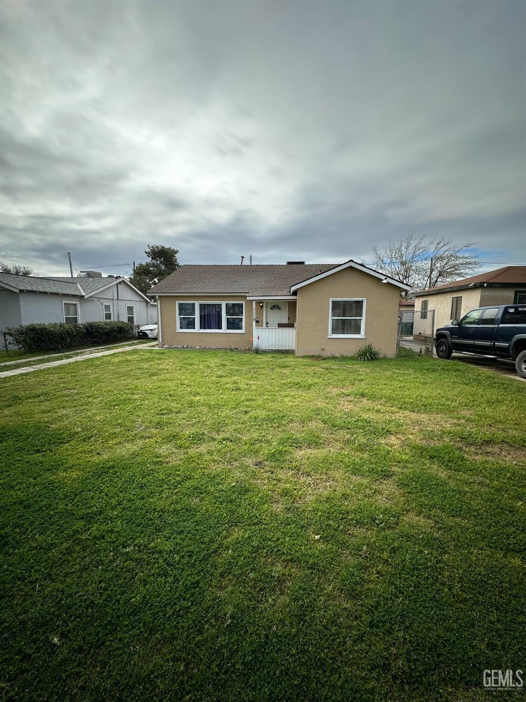 view of front of property featuring stucco siding and a front yard