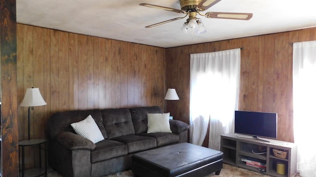 living room with ceiling fan and wooden walls