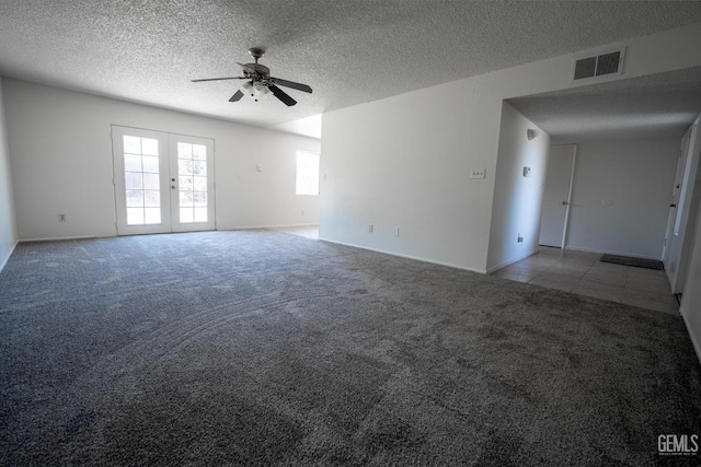 empty room featuring a textured ceiling, ceiling fan, light carpet, and french doors