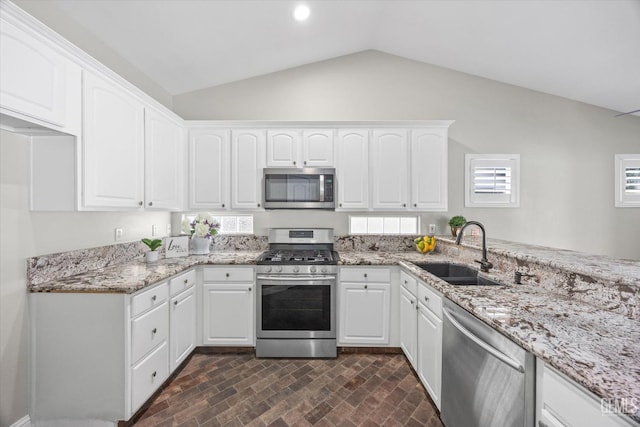 kitchen with stainless steel appliances, white cabinets, a sink, and light stone counters