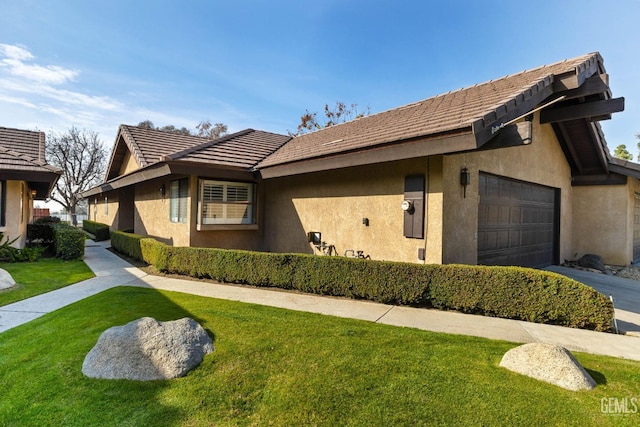 ranch-style house featuring a garage and a front yard