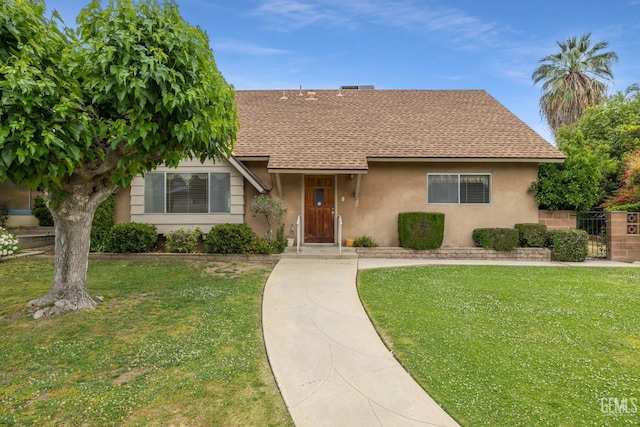 view of front of property with a shingled roof, fence, stucco siding, and a front lawn