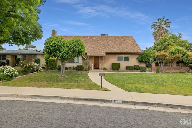 view of front of property featuring fence, a front yard, and stucco siding