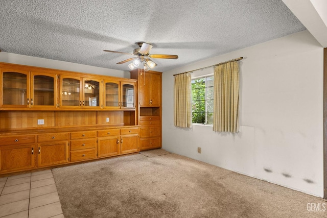 unfurnished room with a ceiling fan and a textured ceiling