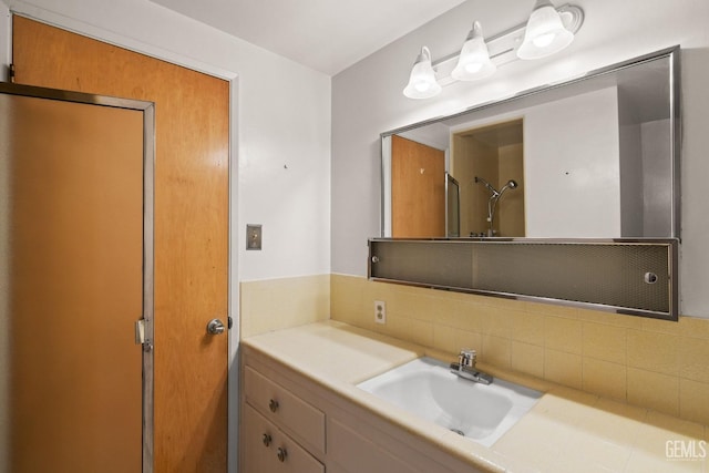 bathroom featuring vanity, walk in shower, and tasteful backsplash
