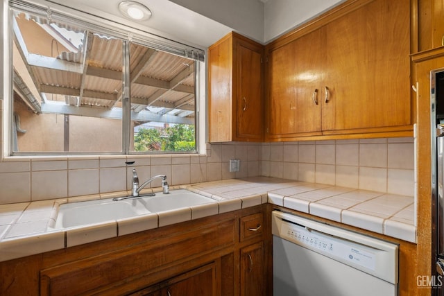 kitchen with decorative backsplash, dishwasher, and brown cabinets