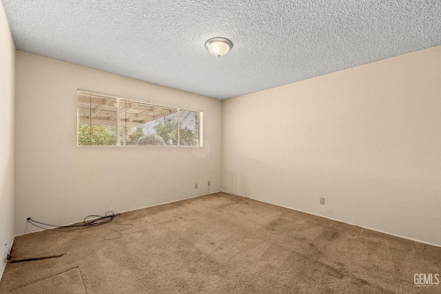 carpeted empty room featuring a textured ceiling