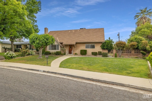 view of front of home featuring fence, stucco siding, a chimney, and a front yard