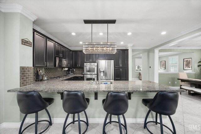 28537 Vista Del Rio Dr, Valencia, CA 91354 - kitchen with stainless steel appliances, ornamental molding, light stone countertops, backsplash, and a peninsula
