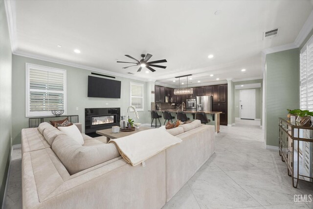 28537 Vista Del Rio Dr, Valencia, CA 91354 - living room featuring recessed lighting, ornamental molding, a ceiling fan, a glass covered fireplace, and light marble finish floors