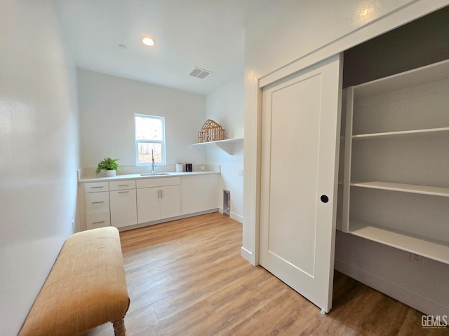 interior space with a sink, visible vents, light wood-style floors, and recessed lighting