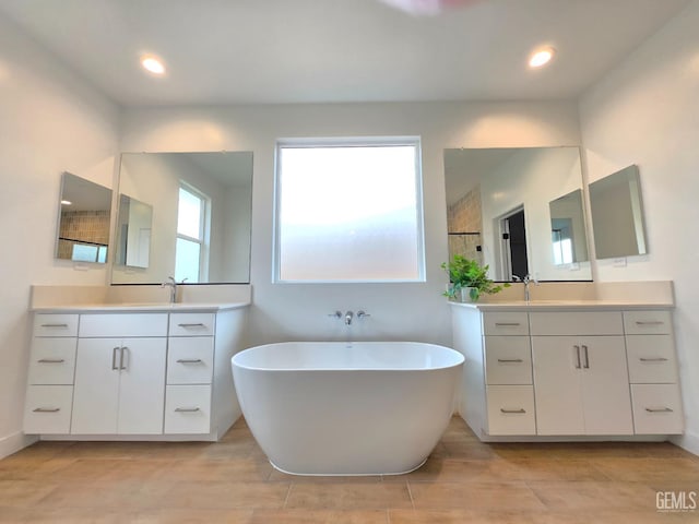 bathroom with recessed lighting, a soaking tub, two vanities, and wood tiled floor