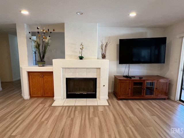 7412 Indian Gulch St, Bakersfield, CA 93313 - living area with light wood-type flooring, a tile fireplace, and recessed lighting