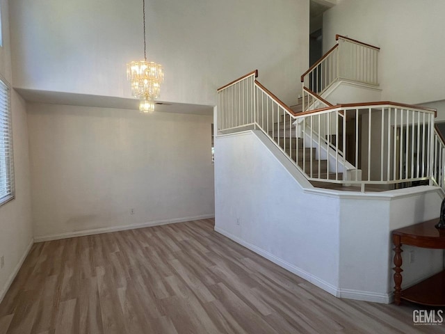 7412 Indian Gulch St, Bakersfield, CA 93313 - stairs featuring wood finished floors, a high ceiling, and a chandelier