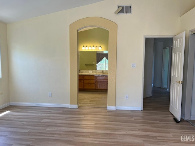 7412 Indian Gulch St, Bakersfield, CA 93313 - empty room featuring light wood-style flooring and arched walkways