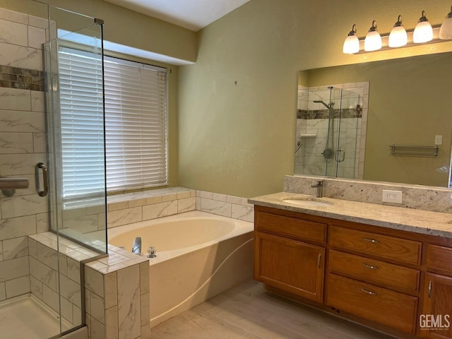 7412 Indian Gulch St, Bakersfield, CA 93313 - bathroom featuring vanity, a garden tub, a shower stall, and wood finished floors