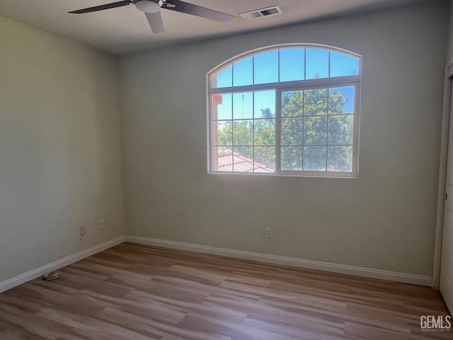 7412 Indian Gulch St, Bakersfield, CA 93313 - empty room with healthy amount of natural light, ceiling fan, and wood finished floors