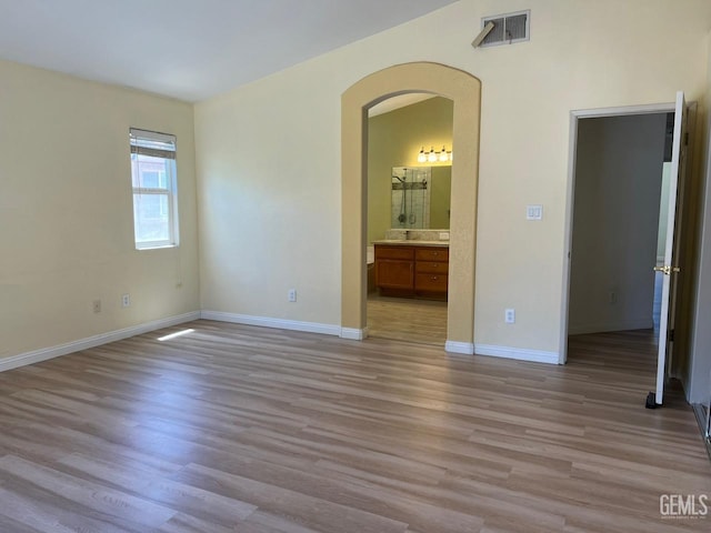 7412 Indian Gulch St, Bakersfield, CA 93313 - unfurnished bedroom with arched walkways, light wood finished floors, and ensuite bathroom