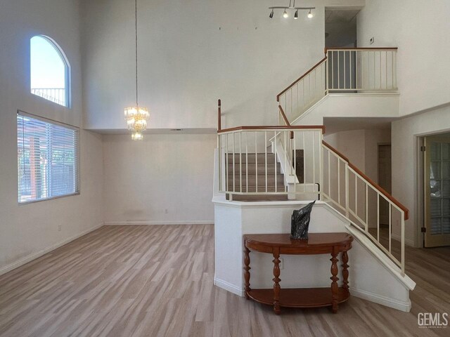 7412 Indian Gulch St, Bakersfield, CA 93313 - unfurnished living room featuring a high ceiling, a chandelier, wood finished floors, and stairway