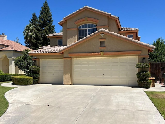 7412 Indian Gulch St, Bakersfield, CA 93313 - mediterranean / spanish-style house with concrete driveway, a tiled roof, stucco siding, and an attached garage