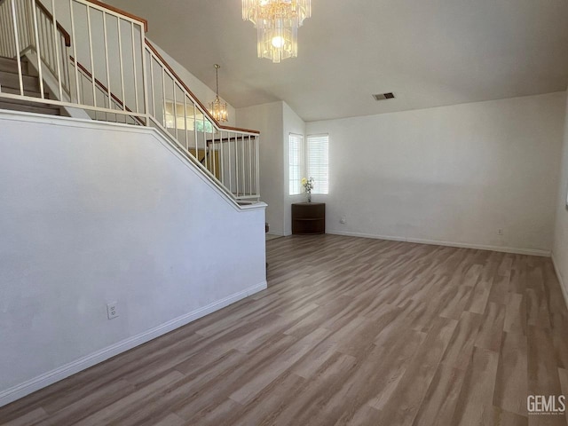 7412 Indian Gulch St, Bakersfield, CA 93313 - unfurnished living room featuring a chandelier, stairs, wood finished floors, and lofted ceiling