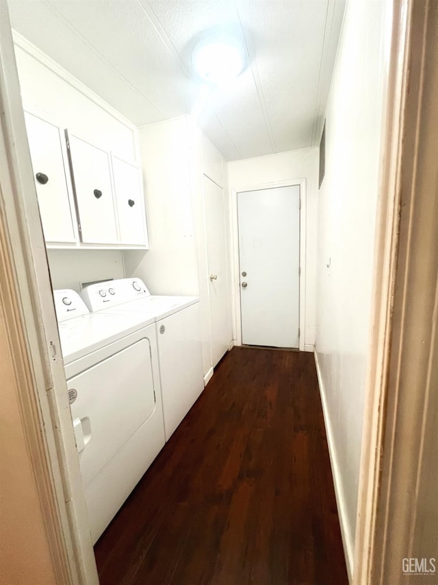 washroom with dark wood-style flooring, independent washer and dryer, and cabinet space