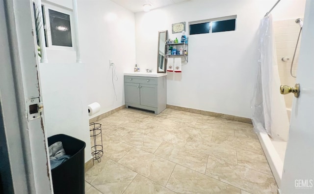 full bathroom with curtained shower, vanity, and baseboards