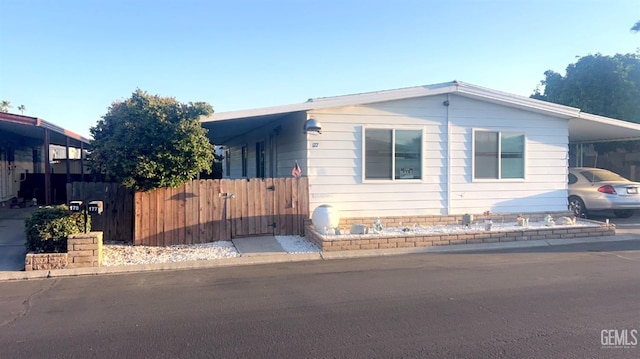 view of front of home featuring fence and a carport