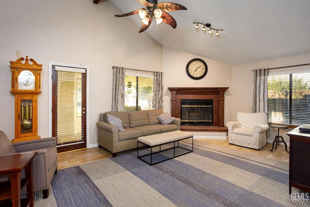 9604 Lea Oak Rd, Bakersfield, CA 93311 - living room featuring lofted ceiling, a ceiling fan, wood finished floors, a glass covered fireplace, and a textured ceiling