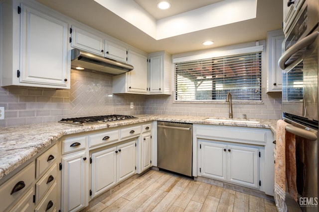 9604 Lea Oak Rd, Bakersfield, CA 93311 - kitchen with stainless steel appliances, a sink, under cabinet range hood, light wood finished floors, and white cabinetry