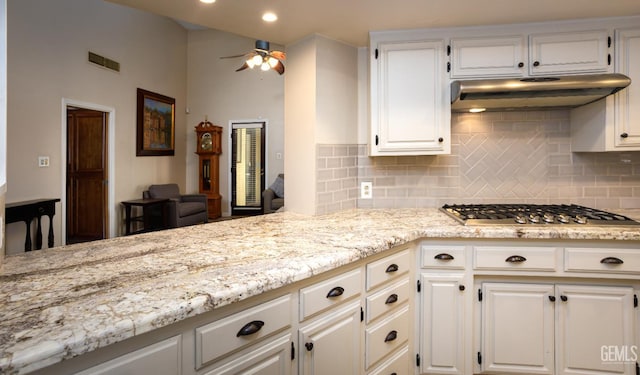 9604 Lea Oak Rd, Bakersfield, CA 93311 - kitchen with stainless steel gas stovetop, under cabinet range hood, white cabinetry, backsplash, and recessed lighting