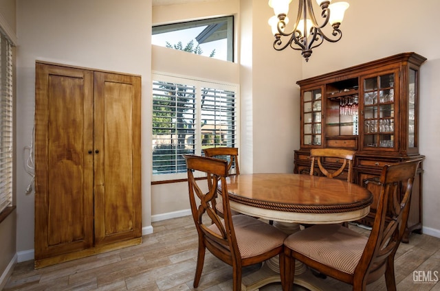 9604 Lea Oak Rd, Bakersfield, CA 93311 - dining space with a chandelier, plenty of natural light, light wood-style floors, baseboards, and a high ceiling