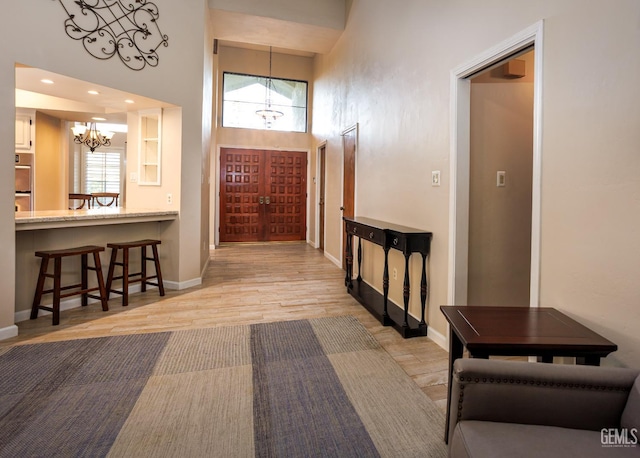 9604 Lea Oak Rd, Bakersfield, CA 93311 - corridor featuring a chandelier, light wood-style flooring, baseboards, and a high ceiling