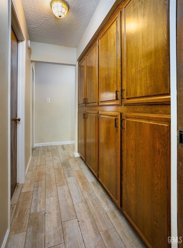 9604 Lea Oak Rd, Bakersfield, CA 93311 - corridor with a textured ceiling, light wood finished floors, and baseboards