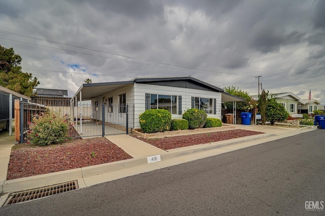400 E Roberts Ln Unit 48, Bakersfield, CA 93308 - manufactured / mobile home featuring an attached carport, a fenced front yard, and a gate