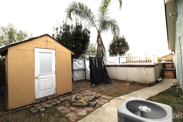 view of shed featuring central AC and fence
