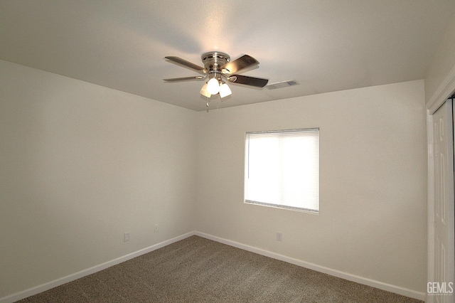 carpeted spare room featuring ceiling fan, baseboards, and visible vents