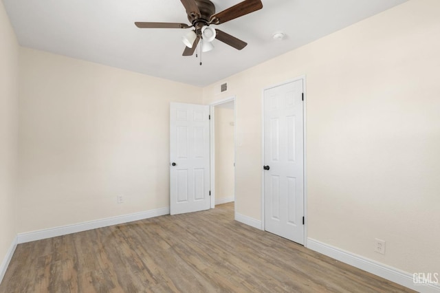 empty room with ceiling fan and light wood-type flooring