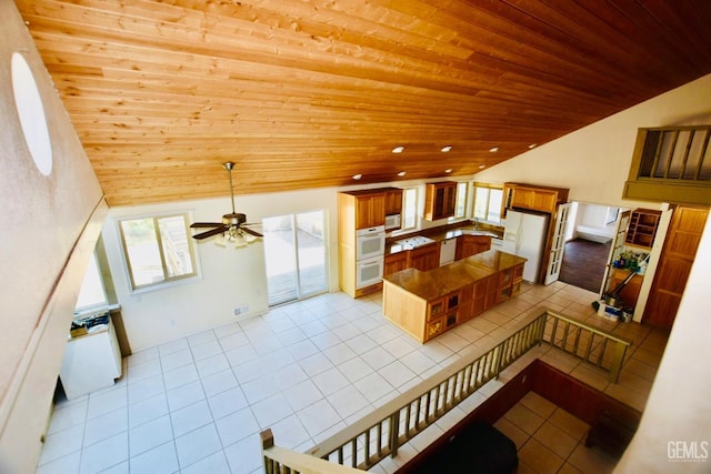 25231 Paramount Dr, Tehachapi, CA 93561 - kitchen with lofted ceiling, wooden ceiling, white appliances, light tile patterned flooring, and ceiling fan