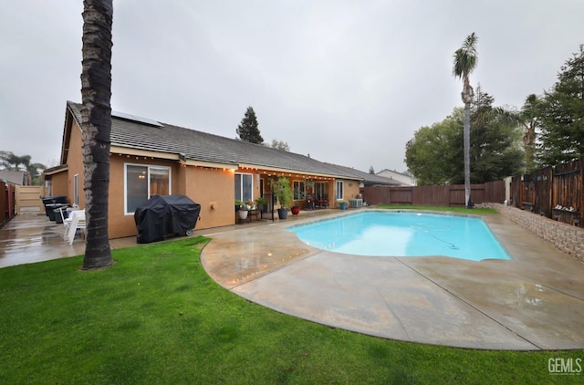 view of swimming pool with a patio, a yard, a fenced backyard, and a grill