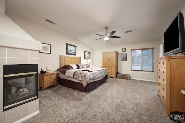 bedroom featuring lofted ceiling, carpet, a fireplace, and visible vents