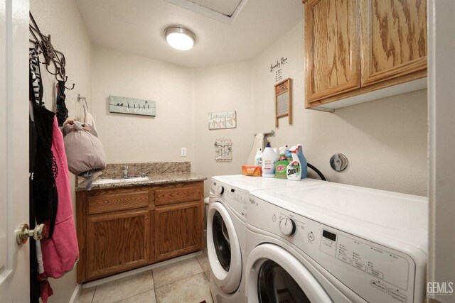 clothes washing area with cabinet space, washer and clothes dryer, and light tile patterned flooring